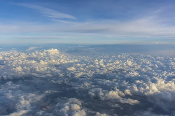 Above clouds, view from pilot cabine airplane. Blue sky, white clouds with magic and soft sun light.