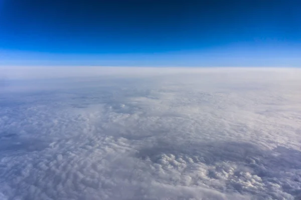 Above clouds, view from pilot cabine airplane. Blue sky, white clouds with magic and soft sun light. — Free Stock Photo