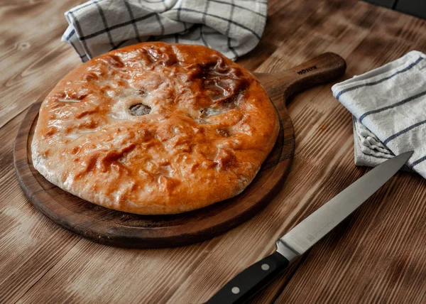 Pasteles tradicionales de carne de Osetia con carne de res sobre un fondo de madera. Estilo rústico, primer plano, enfoque selectivo — Foto de Stock