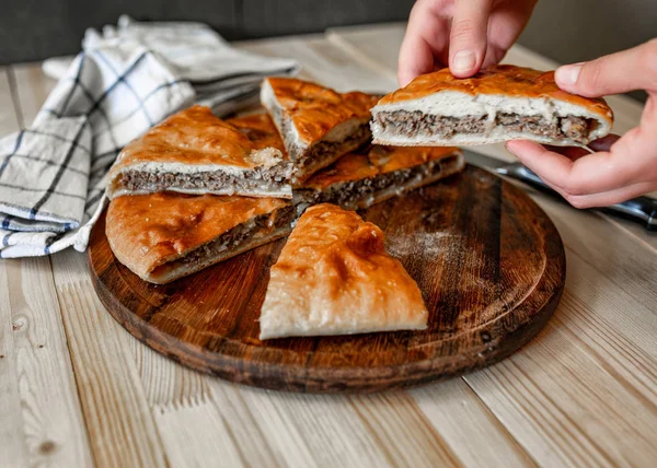 Традиційні Осетинські пироги з яловичиною з жіночою рукою — стокове фото
