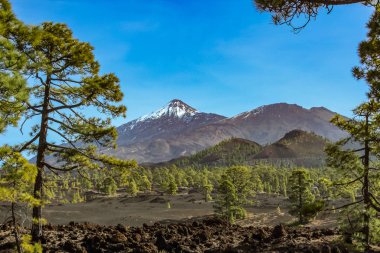 Beyaz kar lekeleri ile dağ Teide, kısmen bulutlar kaplı. Parlak mavi gökyüzü. Teide National Park, Tenerife, Kanarya Adaları, Ispanya.