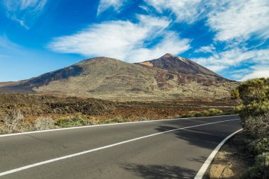 Beyaz kar lekeleri ile dağ Teide, kısmen bulutlar kaplı. Parlak mavi gökyüzü. Teide National Park, Tenerife, Kanarya Adaları, Ispanya.