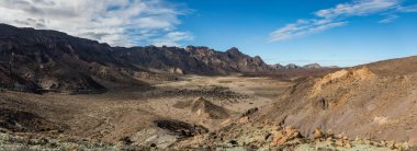 Beyaz kar lekeleri ile dağ Teide, kısmen bulutlar kaplı. Parlak mavi gökyüzü. Teide National Park, Tenerife, Kanarya Adaları, Ispanya.