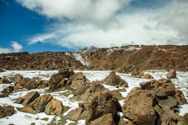 Beyaz kar lekeleri ile dağ Teide, kısmen bulutlar kaplı. Parlak mavi gökyüzü. Teide National Park, Tenerife, Kanarya Adaları, Ispanya.