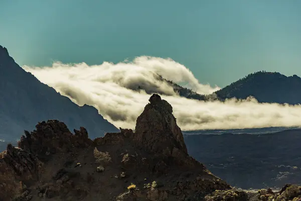 Góra Teide z białymi plamami śniegu, częściowo pokrytymi chmurami. Jasne błękitne niebo. Park Narodowy Teide, Teneryfa, Wyspy Kanaryjskie, Hiszpania. — Zdjęcie stockowe