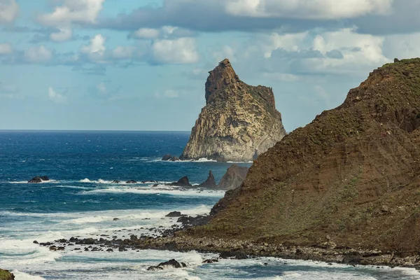 Meredek, magas lávaköves sziklák. Kék tenger horizonton, természetes égbolt háttér. — Stock Fotó