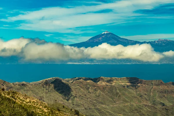Spektakuläre Aussicht auf Teneriffa und den Vulkan Teide mit Schneeflecken auf dem Gipfel. strahlend blauer Himmel und schöne Baumwollwolken. Insel La Gomera, Kanarische Inseln, Spanien — Stockfoto