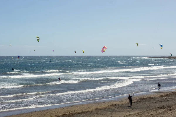 Hermosa vista costera de la playa de El Medano. Brillante cielo azul claro sobre la línea Horizon, ondulaciones de onda en el agua turquesa. Surfistas de viento y cometas en la larga playa de arena. El Medano, Tenerife — Foto de Stock