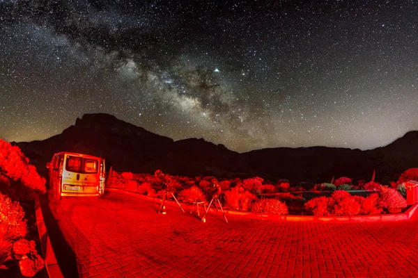 Fotografía de estrellas y vía láctea a cielo alto a través de lente de ojo de pez. Dos telescopios listos para la observación iluminados por las luces traseras del coche en primer plano. Sin Luna. Larga exposición. Parque Nacional del Teide, Tenerife —  Fotos de Stock