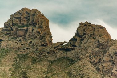 Endemik bitkilerle çevrili yayladaki taşlı yol. Güneşli bir gün. Mavi gökyüzünü ve ufuk çizgisi boyunca bazı bulutları temizleyin. Kuru dağ bölgesinde kayalık izleme yolu. Tenerife