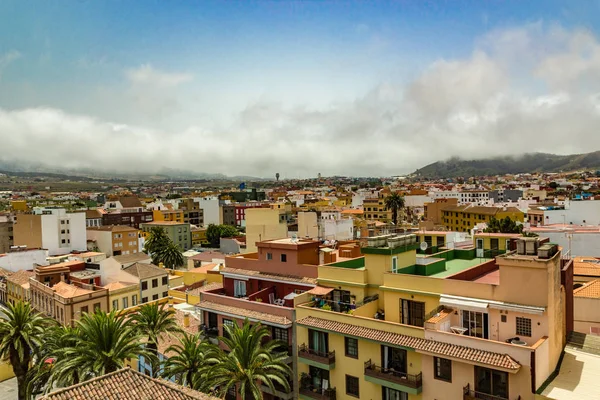 Tenerife'deki tarihi San Cristobal de La Laguna kentinin havadan görünümü arka planda dağları olan binaları ve sokakları gösteriyor