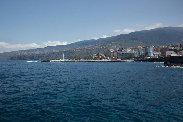 Puerto de la Cruz, Tenerife - April 12, 2017: view of the townscape and the coastline on a sunny day. Fountains of Lago Martianez - famous place for tourists and local people. Wide angle panorama