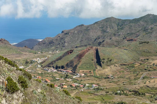 Vale de El Palmar nas montanhas Teno com encostas verdes. No centro - colina vulcânica como uma torta cortada. Marco de Tenerife, Ilhas Canárias .. — Fotografia de Stock