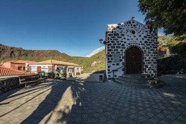Cennet bir adada bahçeler ve subtropikal ormanlarla çevrili sessiz, derin bir geçitte saklanan rahat bir dağ köyü. Güzel sıcak güneşli bir gün. Seyahat fotoğrafı, kartpostal. Masca, Tenerife, İspanya