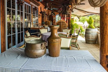 Renkli masa örtüsü ile bir masada Vintage bakır sürahi ve Melon pot. Yerel bir köyde bir rothweinhotel Vintage eski ahşap şarap varil. Bulanık arka plan. Tenerife, Ispanya