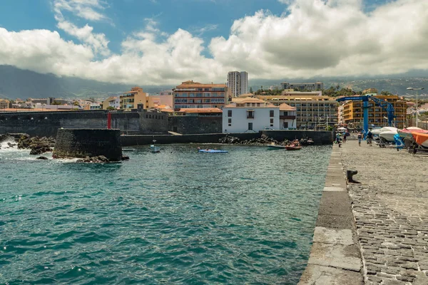 Puerto de la Cruz, Tenerife, España - 10 de julio de 2019:. El puerto antiguo de la ciudad es una atracción turística popular y lugar favorito para los lugareños. Vemos el puerto y las montañas en los alrededores — Foto de Stock