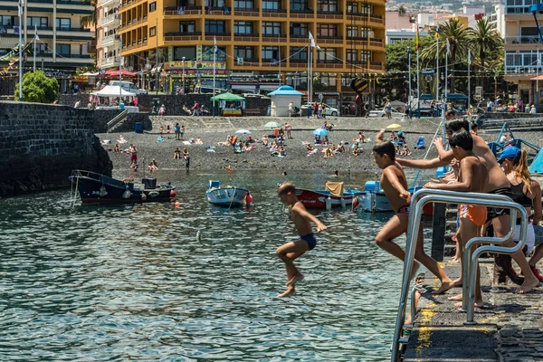 2019-01-12, Puerto de la Cruz, Santa Cruz de Tenerife. El puerto de Puerto de la Cruz es una atracción turística popular y lugar favorito para los lugareños. Los niños toman el sol y saltan desde el muelle — Foto de Stock