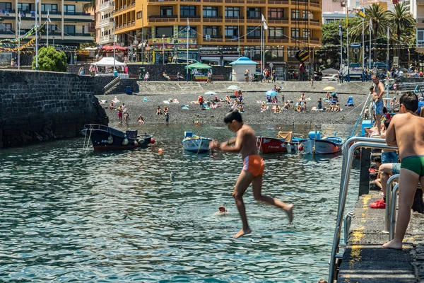 2019-01-12, Puerto de la Cruz, Santa Cruz de Tenerife. El puerto de Puerto de la Cruz es una atracción turística popular y lugar favorito para los lugareños. Los niños toman el sol y saltan desde el muelle — Foto de Stock