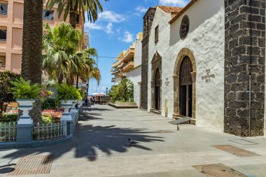 Puerto de la Cruz, Tenerife, Ispanya-10 Temmuz 2019: sokaklarda renkli evler ve palmiye ağaçları. İnsanlar dinlenmek ve sıcak güneşli bir yaz gününde eğlenin. Kahvaltı, rahat bir kafede kahve içmek