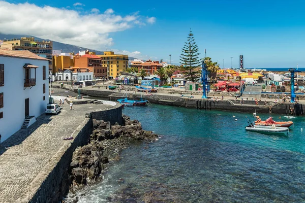Puerto de la Cruz, Tenerife, España - 10 de julio de 2019:. El puerto antiguo de la ciudad es una atracción turística popular y lugar favorito para los lugareños. Vemos el puerto y las montañas en los alrededores — Foto de Stock