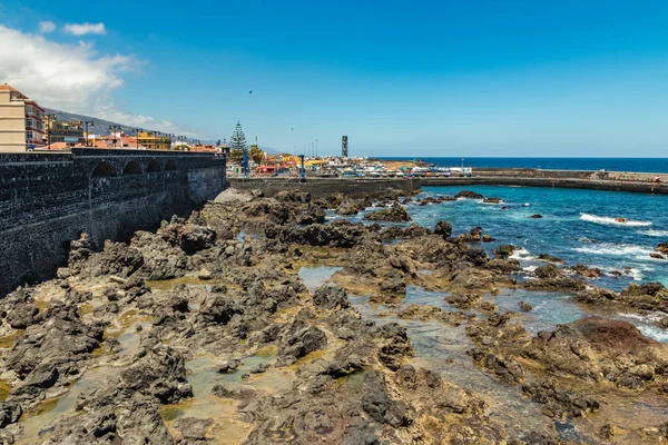 Puerto de la Cruz, Tenerife, España - 10 de julio de 2019:. El puerto antiguo de la ciudad es una atracción turística popular y lugar favorito para los lugareños. Vemos el puerto, caminando y bañando a la gente — Foto de Stock