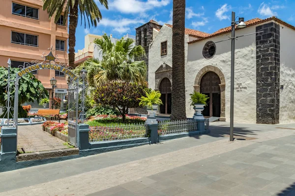 Puerto de la Cruz, Tenerife, Ispanya-10 Temmuz 2019: sokaklarda renkli evler ve palmiye ağaçları. İnsanlar dinlenmek ve sıcak güneşli bir yaz gününde eğlenin. Kahvaltı, rahat bir kafede kahve içmek