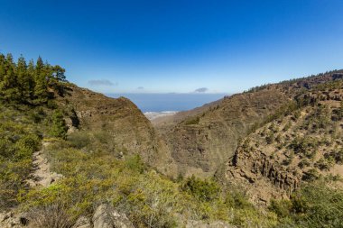 Hell Gorge - Barranco del Infierno, Tenerife 'nin güneyindeki Adeje köyü yakınlarında yer alan bir uçurum. Ufuktaki ince bulutlar, kıyı şeridi ve arka planda Atlantik okyanusu.