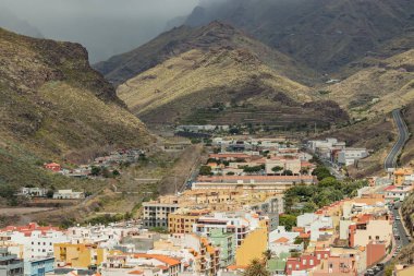 İspanya, San Sebastian de la Gomera 'da volkanın yamacındaki renkli evler.