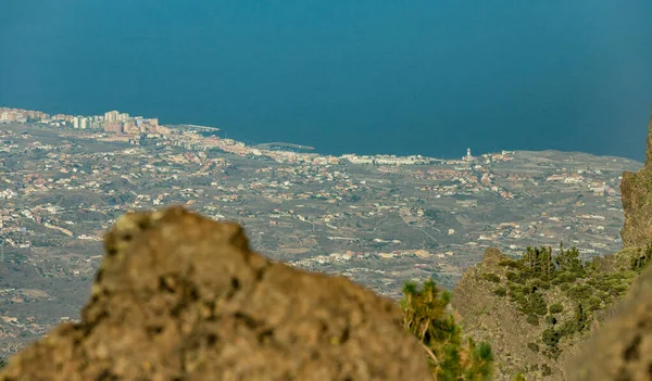 Antenne der Küste. die Stadt Candelaria mit ihrer berühmten Basilika im östlichen Teil Teneriffas auf den spanischen Kanarischen Inseln. selektiver Langfokus mit blauem Felsen im Vordergrund — Stockfoto