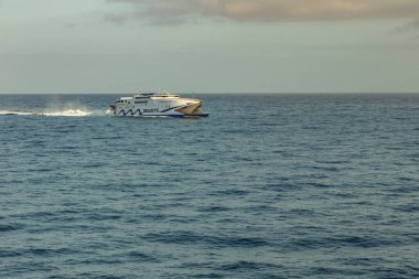 Las Amerika, Tenerife, İspanya - 25 Mayıs 2019: Los Cristianos limanından La Gomera adasına giden başka bir feribottan kalkan küçük hızlı feribota bakın.