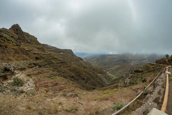 在自然公园山中一条狭窄的乡村小道的紧要关头之一。 峡谷和拉戈梅拉岛首府圣塞巴斯蒂安的景色。 加那利群岛，西班牙 — 图库照片
