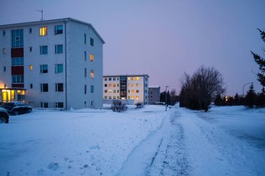 Reykjavik, İzlanda kar kaplı modern konut kadeh akşam geç. Kış İskandinav cityscape boş sokakları ile.