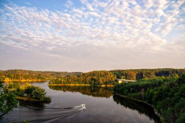 Bir göl üzerinde renkli gün batımı. Güneş ayarı ile geniş nehir manzara yaz sahne. Nehir küçük tekne yelken.