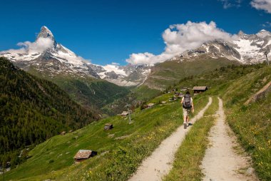 Dağ izi yürüyüş ve İsviçre Valais (Pennine) Alpleri'nde görkemli Matterhorn dağ manzarasına hayran sırt çantası ile kadın gezgin.