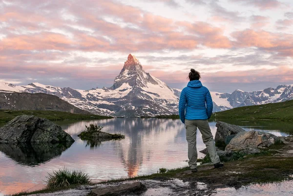 Sabah altın Matterhorn (Monte Cervino, Mont Cervin) piramit ve Stellisee Gölü mavi. Valais Alpler, İsviçre kadın turist sabah erken Matterhorn dağ manzarasına zevk olduğunu.