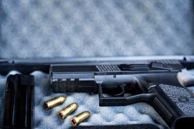 Mermi ve tabanca görünümünü kapatın. Küçük siyah tabanca 9 mm mermiler ve bir dergi yanında. Sığ derinlik-in tarla.