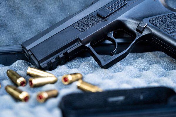 Close up view of bullets and handgun. Shallow depth of field. Focus on a pistol.