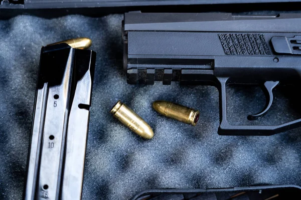 Mermi ve tabanca görünümünü kapatın. Küçük siyah tabanca 9 mm mermiler ve bir dergi yanında. Sığ derinlik-in tarla.