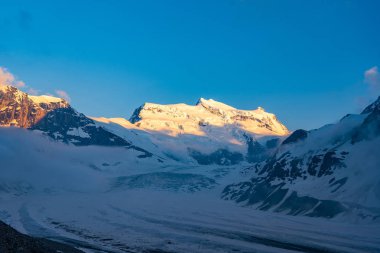 Doğal görünümü ile görkemli bir buzul de Corbassiere İsviçre İsviçre Alpleri'nin güzel manzara. Yüksek dağlar dramatik günbatımı sahnede. Valais Alpler (Pennine Alps), İsviçre bir akşam ışık yüksek doruklarına kapsayan bulutlar.
