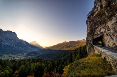 Sabah erken görünümü dağların güzel Dolomites İtalyan Alpleri'nde Cortina d'Ampezzo bir vadide bir tünelde giden dağ yolu ile.