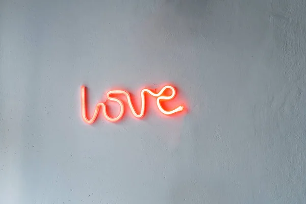 Red Neon Love Sign on a white wall.