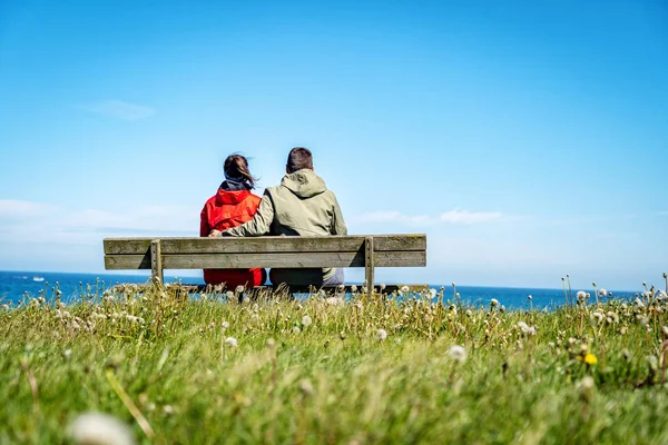 Dos Adultos Jóvenes Sentados Banco Madera Junto Mar Disfrutando Una — Foto de Stock