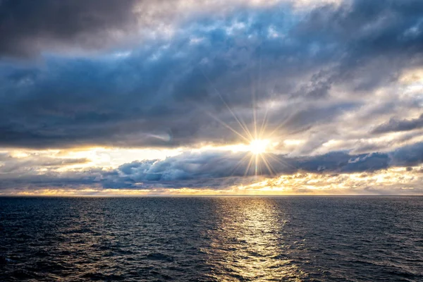 On a cruise ship during a stormy weather in Atlanic Ocean. Beautiful rainy clouds over Atlanic ocean during colorful sunset.