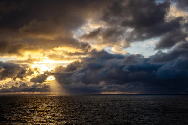 On a cruise ship during a stormy weather in Atlanic Ocean. Beautiful rainy clouds over Atlanic ocean during colorful sunset.