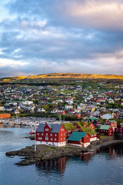 Kuzey Atlantik 'teki Faroe Adaları' nın başkenti Torshavn 'ın gündoğumu sahnesi. Sıcak altın güneş ışığı altında İskandinav şehrinin şehir manzarası.