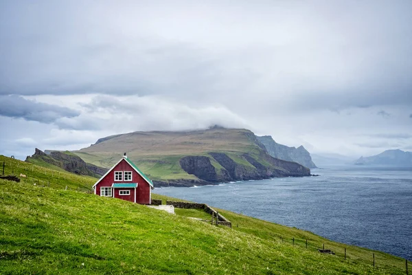 Faroe Adaları, Mikynes Adası 'nın dramatik manzarası. Faroe Adaları 'ndaki Mykines' de okyanusa bakan dev deniz kayalıklarının manzarası..