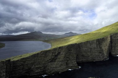 Faroe Adaları 'ndaki sonsuz göl üzerinde Sorvagsvatn (veya Leitisvatn) ile dramatik manzara.