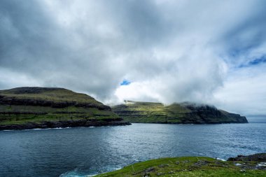 Faroe Adaları 'ndaki bulutlarla kaplı dağların muhteşem manzarası..