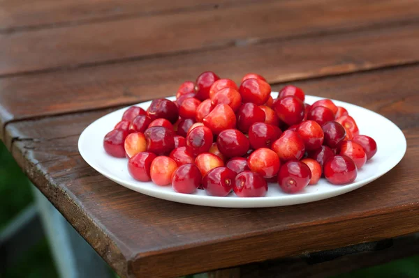 Gele Rode Kers Een Witte Plaat Een Houten Donkere Tafel — Stockfoto