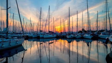 Limandaki teknelerin üzerinde gün batımı